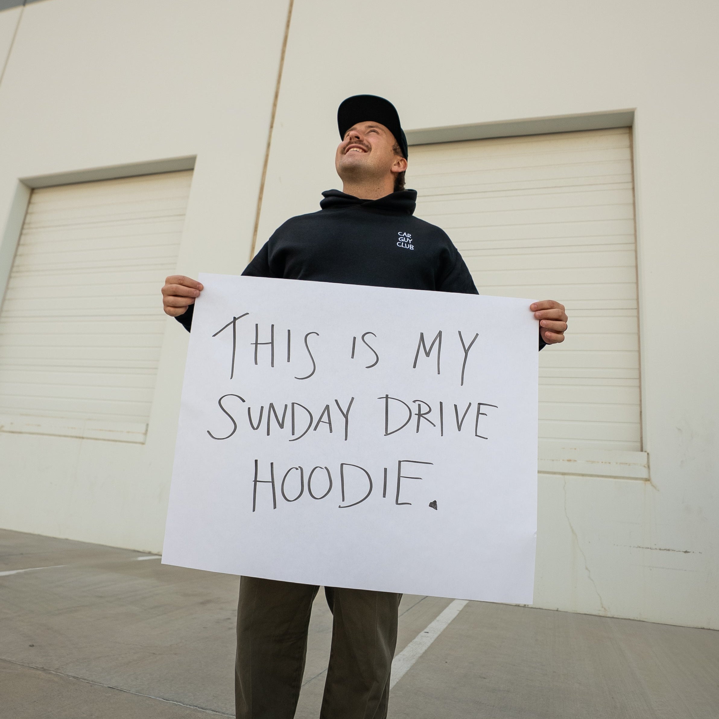 Person holding a sign in front of a building